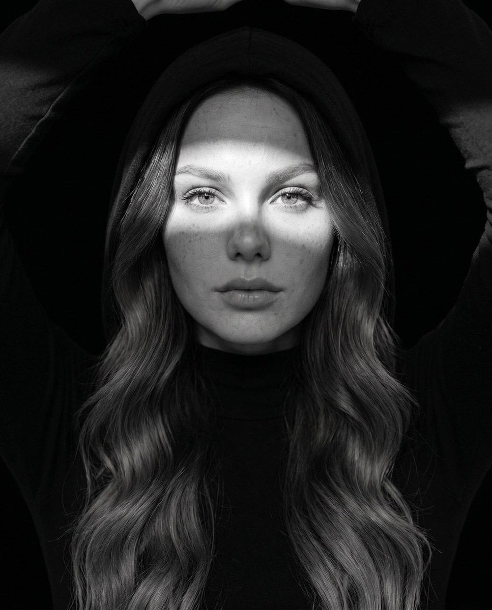 Halloween AI photo prompt example — black and white hooded portrait with dramatic light beam